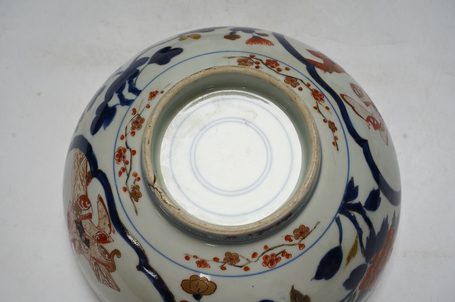 A Japanese Arita polychrome bowl, c.1700, diameter 24.5cm, height 12.5cm, on a carved hardwood stand. Condition - large overglazed open firing crack to foot, otherwise good